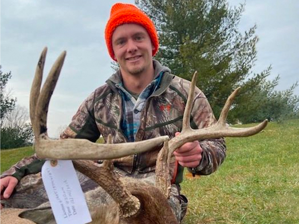 man with buck from muzzleloader hunt