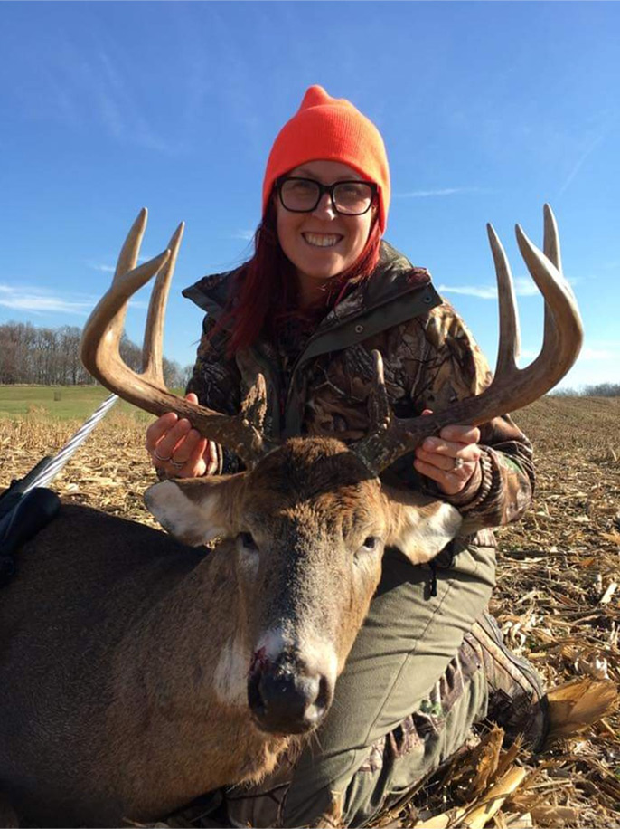Midwest gun hunt woman with whitetail deer